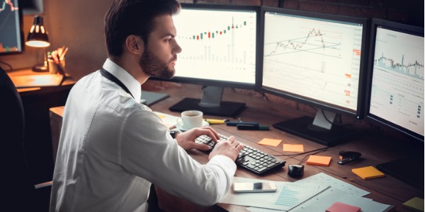 A position trader looking at stock charts on his computer.