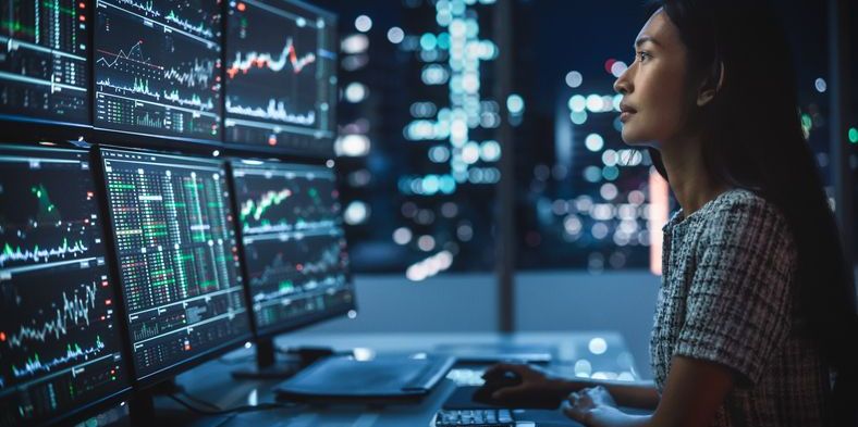 A scalper trader closely watching several monitors showing technical analysis.