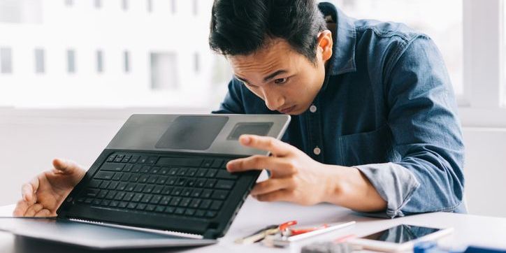 A laptop technician inspecting a laptop.