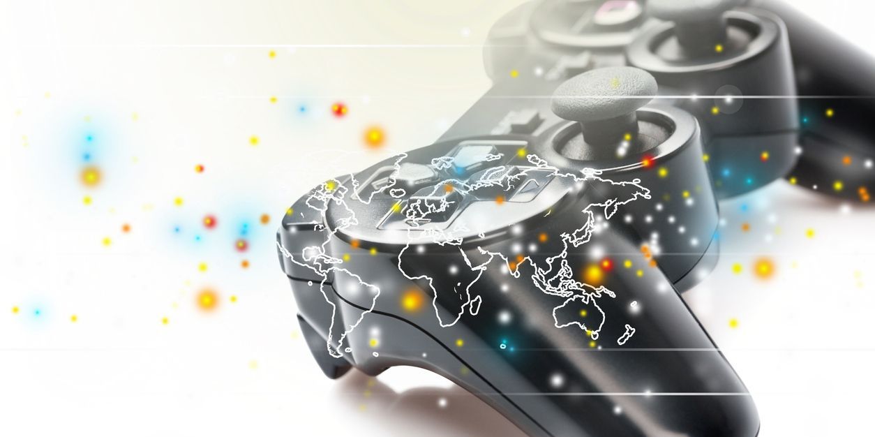 Joystick with world map on grey background, depicting video game localization.
