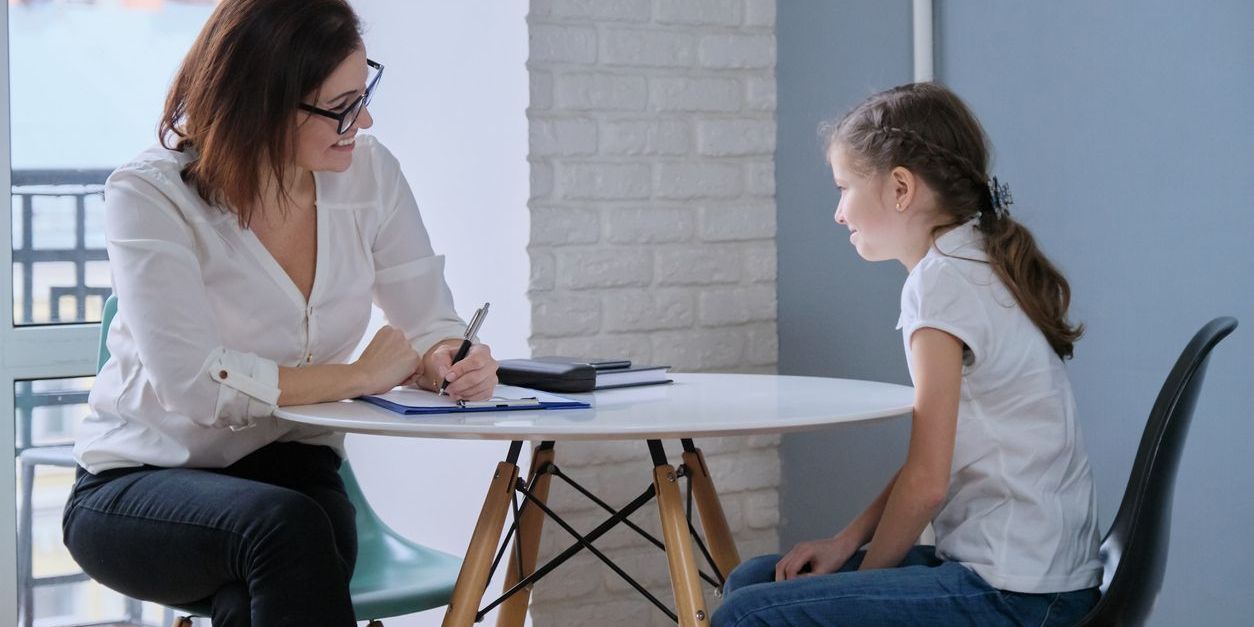 A school social worker having a one-to-one counseling session with a young female student.
