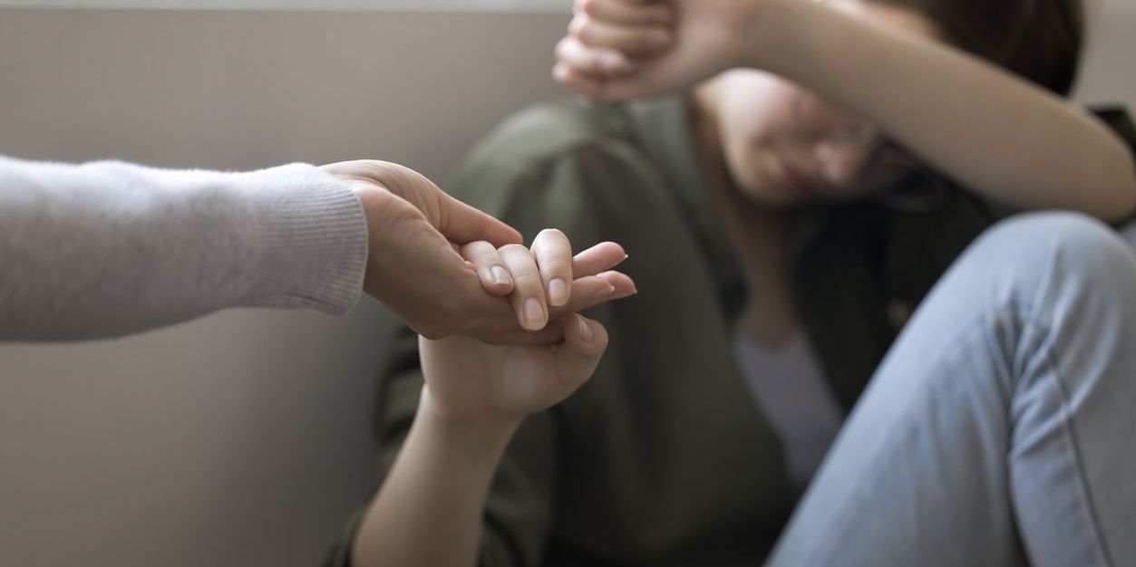 A victim advocate providing emotional support to a young girl.