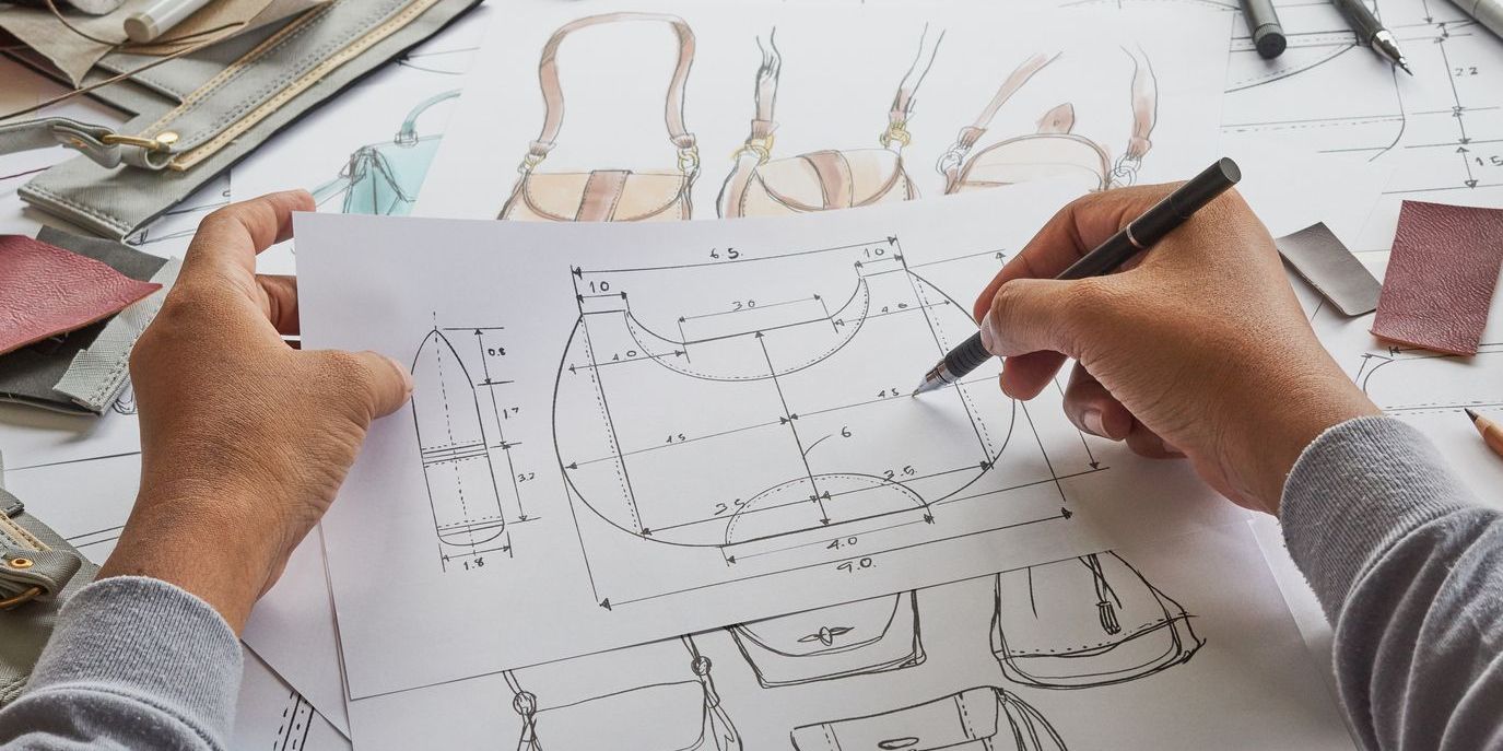 A product developer overseeing the design of a leather handbag.