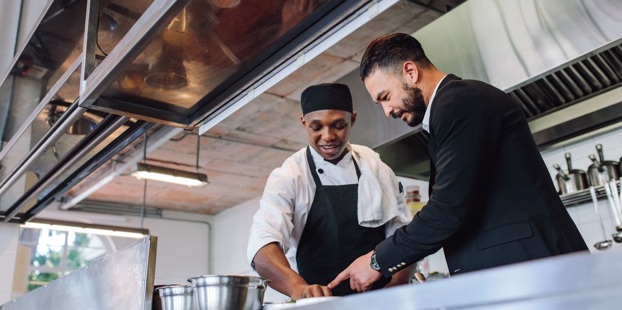 A restaurant general manager discussing a new menu item with the head cook.