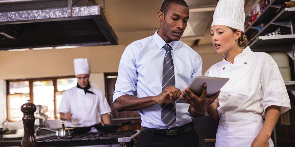 A restaurant back of house manager talking to the chef.