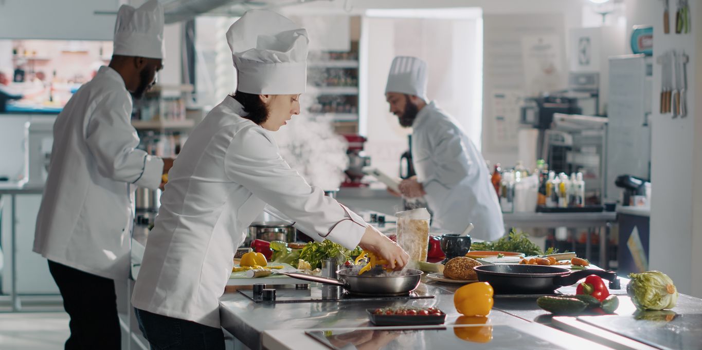 A chef tournant cooking in a restaurant kitchen.