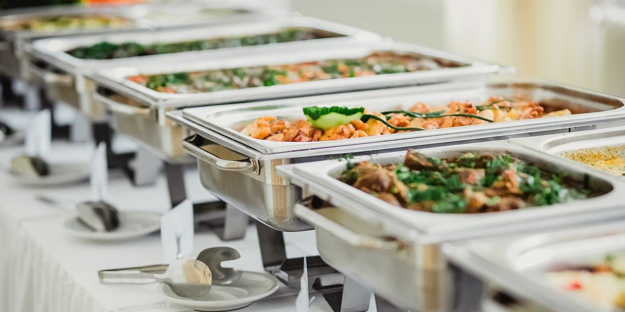Many trays of food served at a banquet, and prepared by a banquet chef.