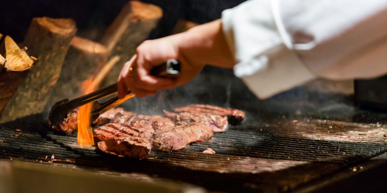 A grill chef cooking steaks.