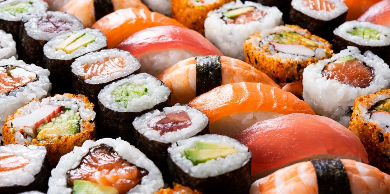 Various types of sushi prepared by a sushi chef.