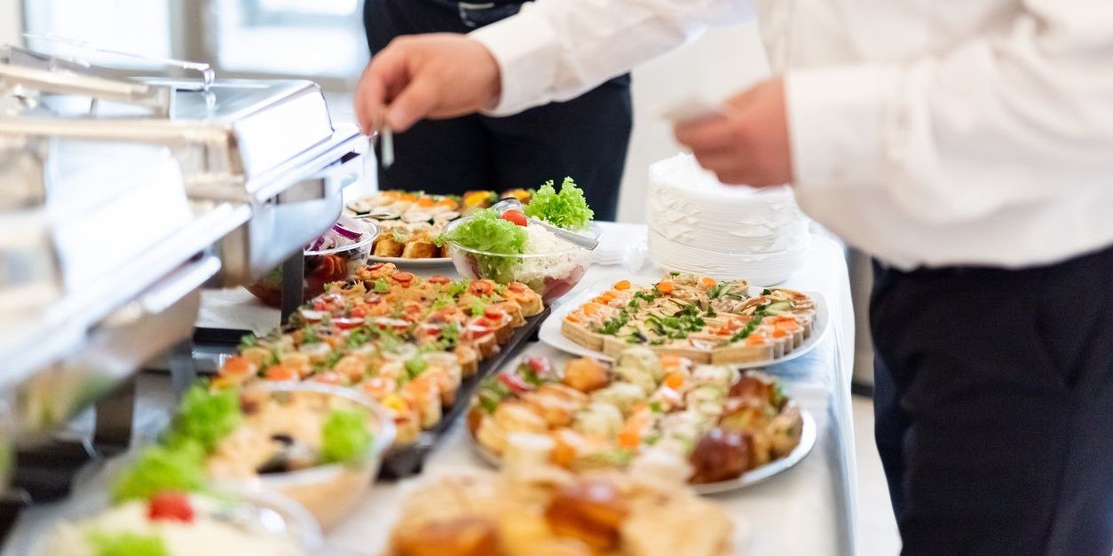 A social event caterer putting canapes on a table for the guests.