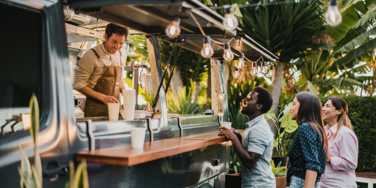 A food truck owner serving customers.