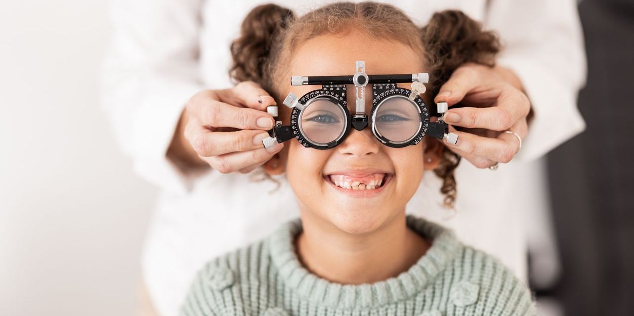 A pediatric optometrist checking a young girl's vision.