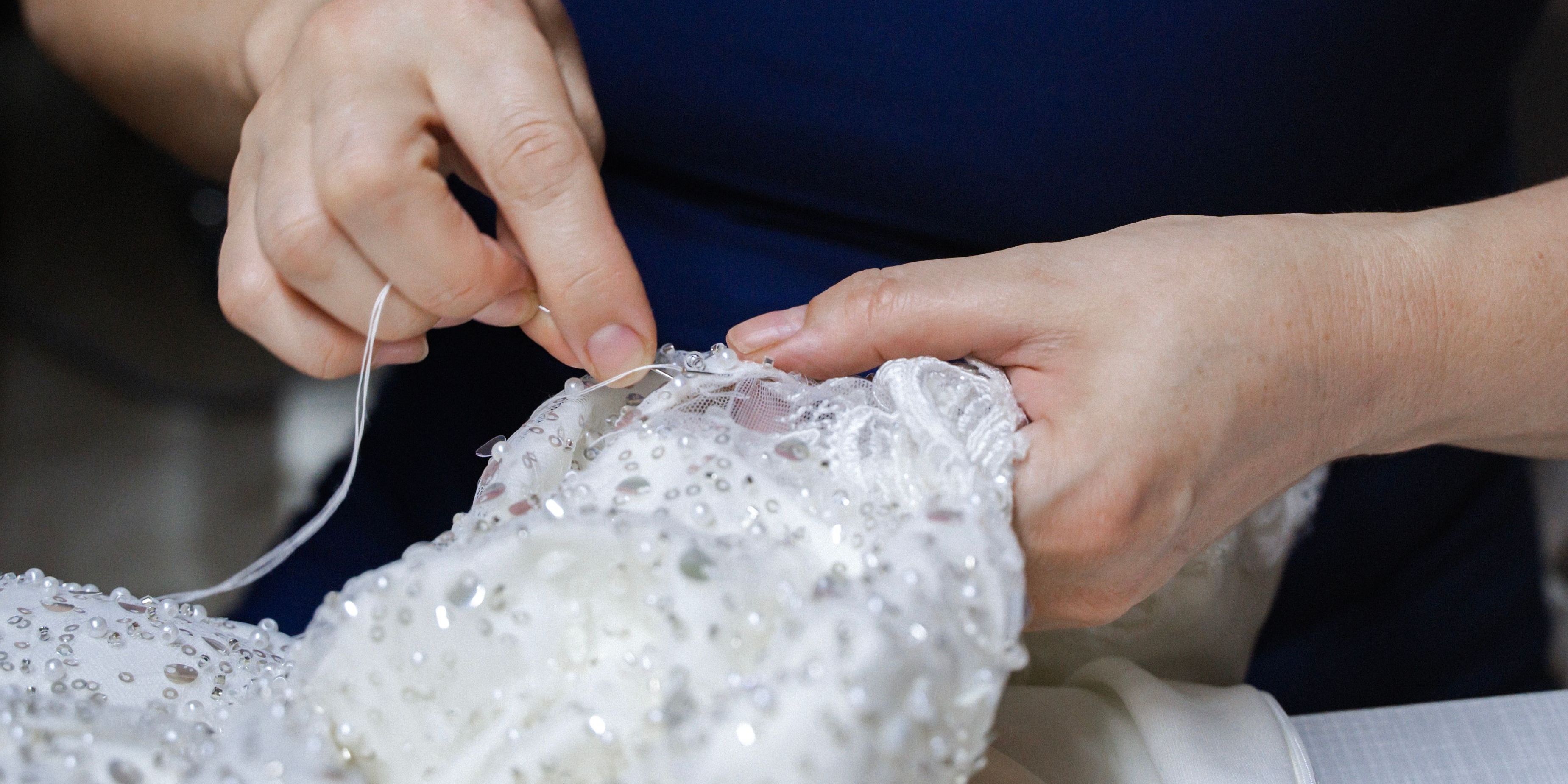 A bridal seamstress sewing a bridal dress.