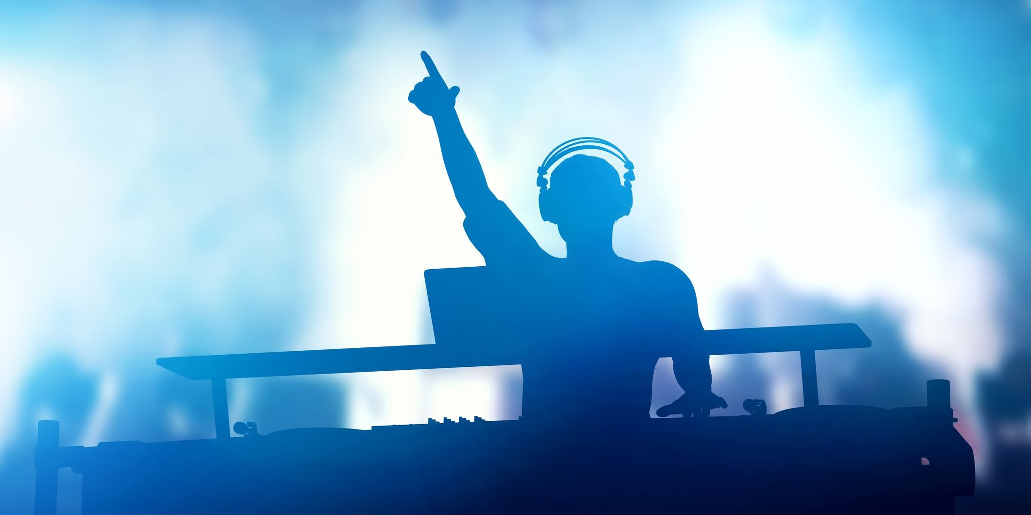 A club DJ mixing music in front of a crowd.