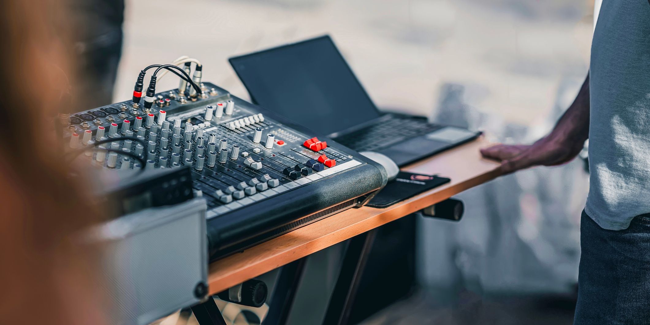 A mobile DJ setting up his equipment at a beach venue.
