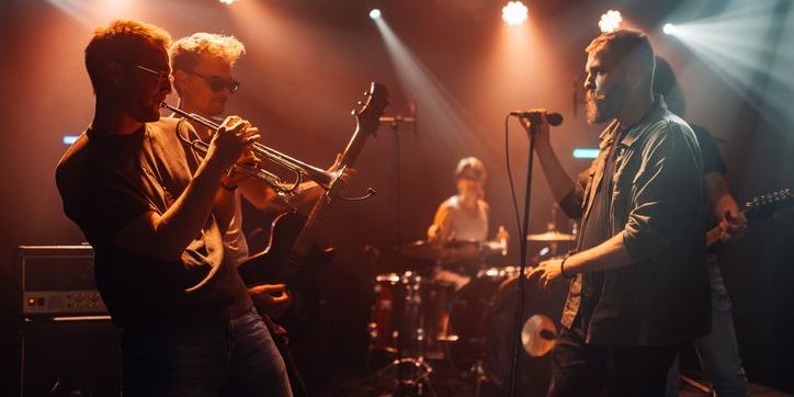 Musicians playing at a club, organized and publicized by a music club promoter.