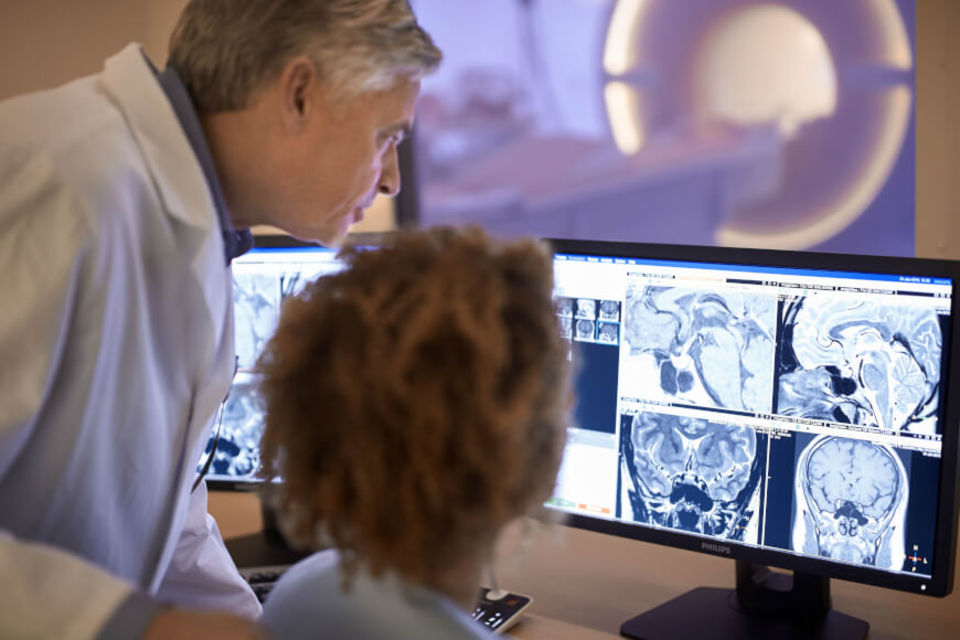 A photo of two radiologists reviewing MRI charts.