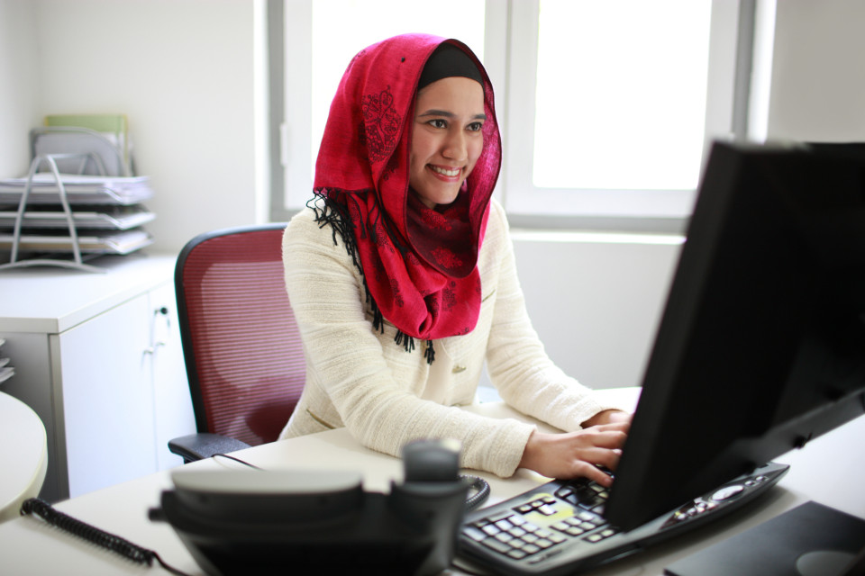 A photo of a travel agent working at her computer.