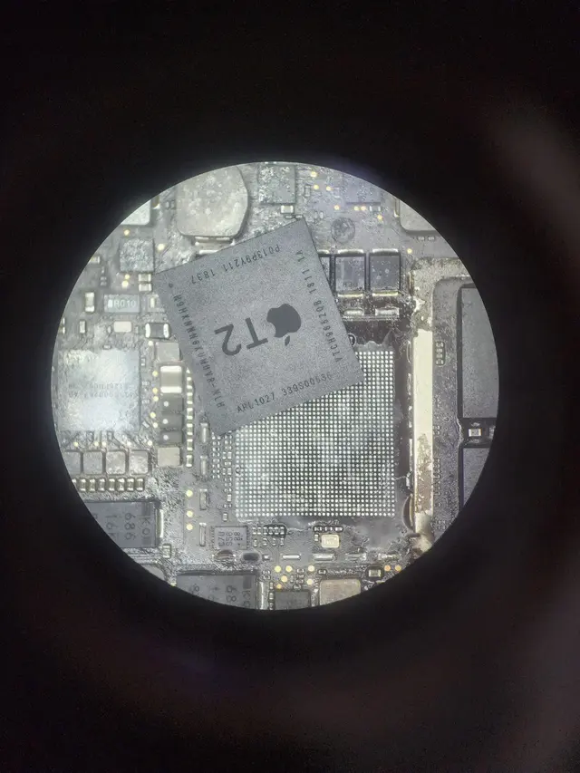 Pengerjaan chip-level logicboard MacBook di bawah mikroskop