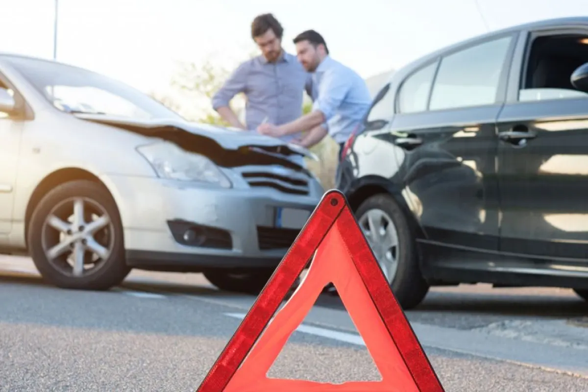 Zwei Autos nach einem Auffahrunfall mit sichtbaren Schäden an der Frontpartie. Ein Warndreieck steht auf der Straße.