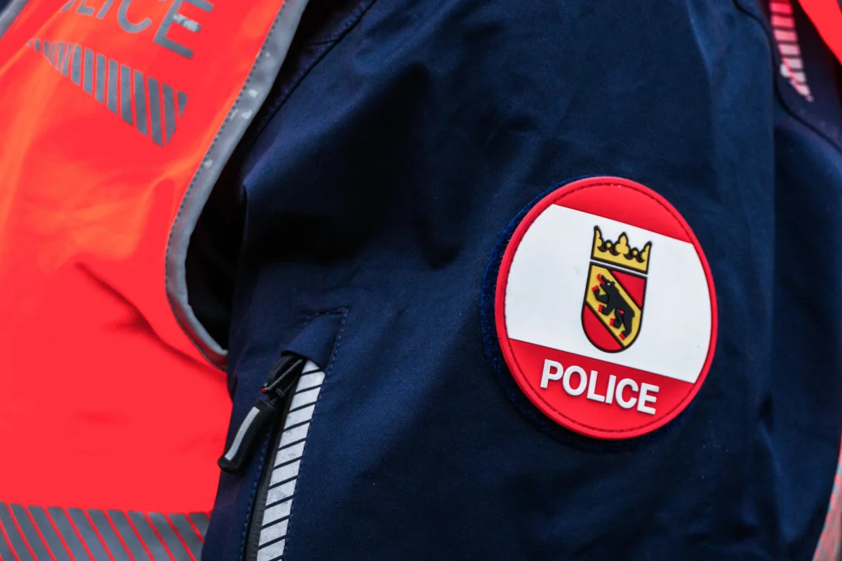 Ein rotes Polizeiabzeichen mit dem Wappen des Kantons Bern auf einer blauen Uniform. Das Wappen zeigt einen Bären.