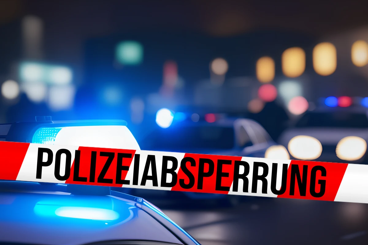 Ein Polizeiabsperrband ist im Vordergrund zu sehen, während dahinter mehrere Polizeifahrzeuge unscharf sichtbar sind.