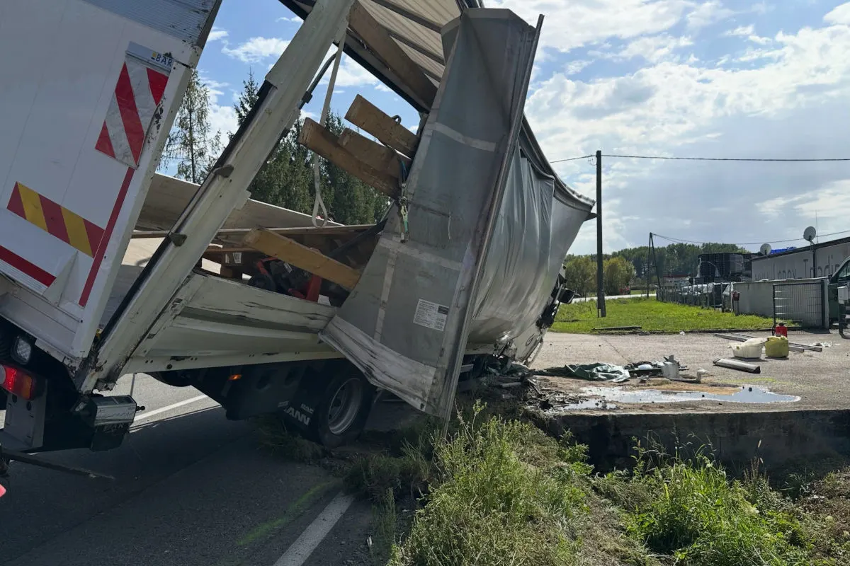 Ein Lkw hat durch einen Unfall schweren Schaden genommen. Die Ladung ist aus dem Fahrzeug gefallen und liegt verstreut auf der Straße.