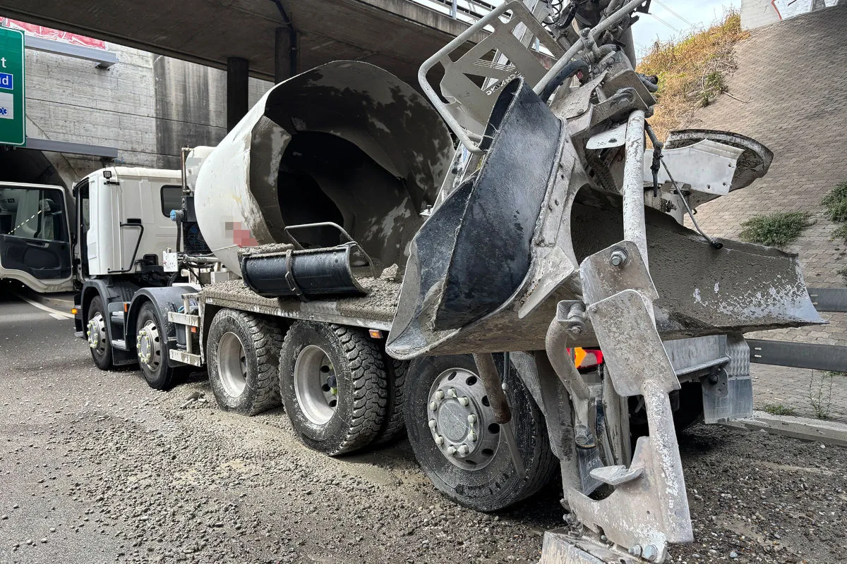 Ein Betonmischer hat unter einer Brücke Ladung verloren. Der Beton ist auf die Fahrbahn und die Umgebung verteilt.