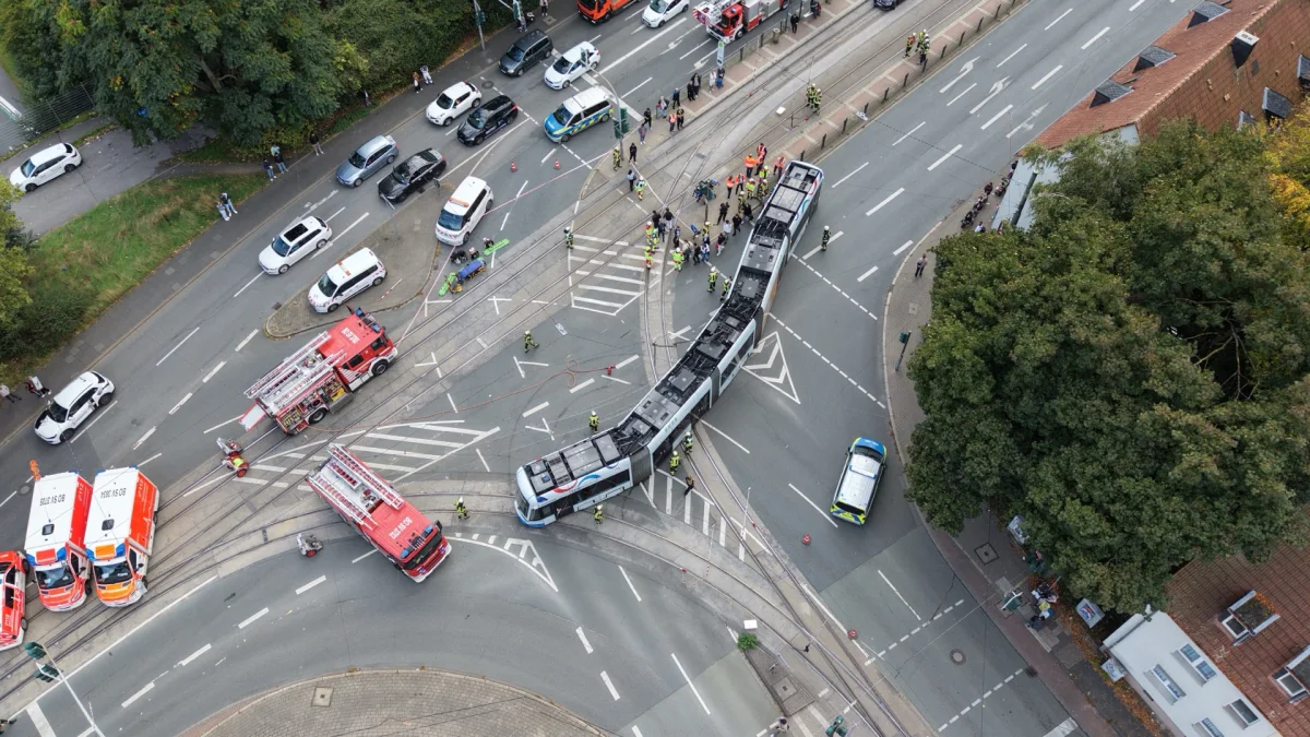 Eine Straßenbahn hat sich auf einer Großstadtkreuzung entgleist. Mehrere Einsatzfahrzeuge der Polizei und Feuerwehr sind anwesend und versuchen die Lage zu klären. Ein Rettungseinsatz ist im Gang.