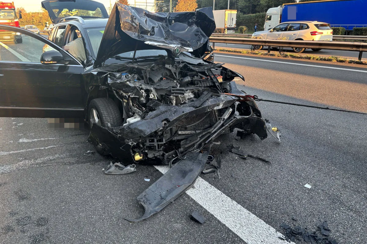 Ein stark beschädigtes Auto steht auf einer Autobahn. Die Front ist komplett eingedrückt und Trümmer liegen auf der Fahrbahn.