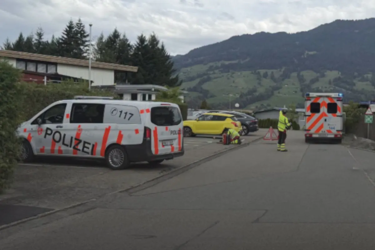 Ein Polizeifahrzeug und ein Rettungswagen stehen neben einem gelben Pkw in einer ländlichen Umgebung. Ein Mann in Warnkleidung arbeitet nahe dem Auto.