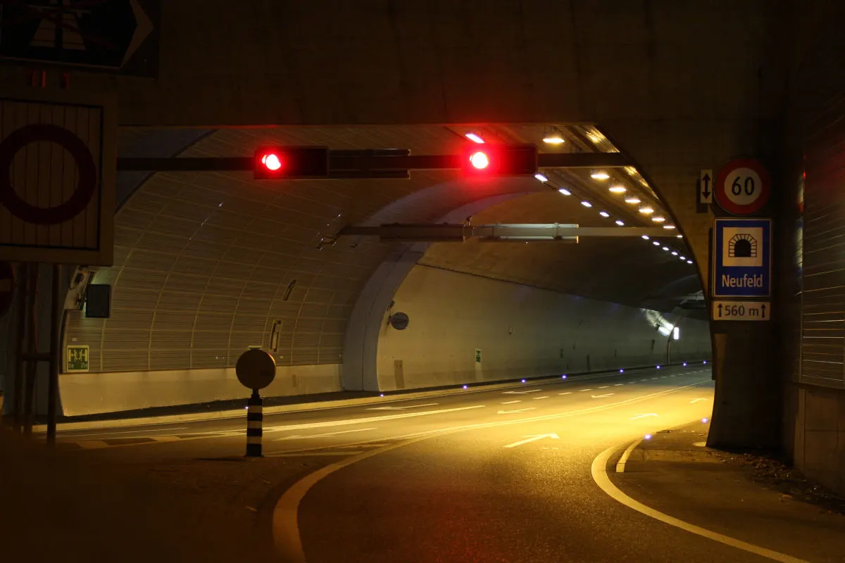 Ein heller Tunnel wird am Eingang von einem roten Stopplicht gesperrt. Der Tunnel ist leer und beleuchtet.
