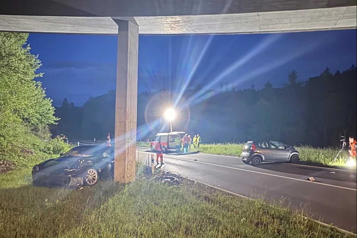 Ein Unfallwagen ist in einen Brückenpfeiler gekracht, daneben ein weiteres Fahrzeug. Personen stehen in reflektierender Kleidung auf der Straße.