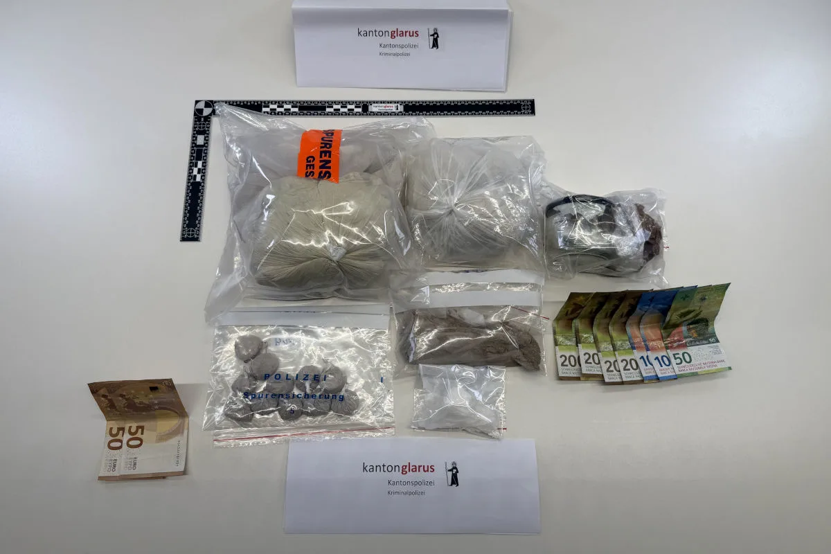 Mehrere Tüten mit Drogen und Bargeldscheinen liegen auf einem Tisch. Ein Schild mit 'Kantonspolizei Glarus'.