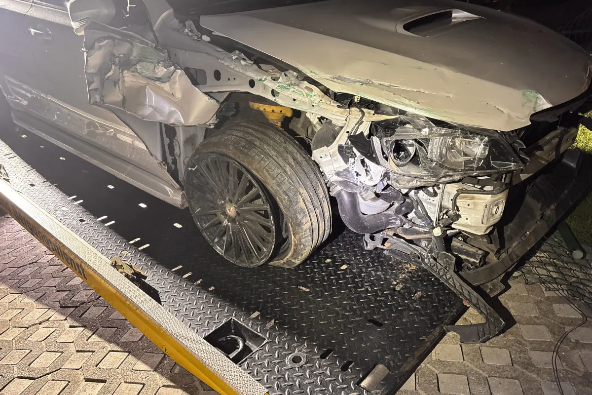 Ein stark beschädigtes Auto steht auf einem Abschleppwagen. Das Fahrzeug hat erhebliche Schäden an der Front und Seite.