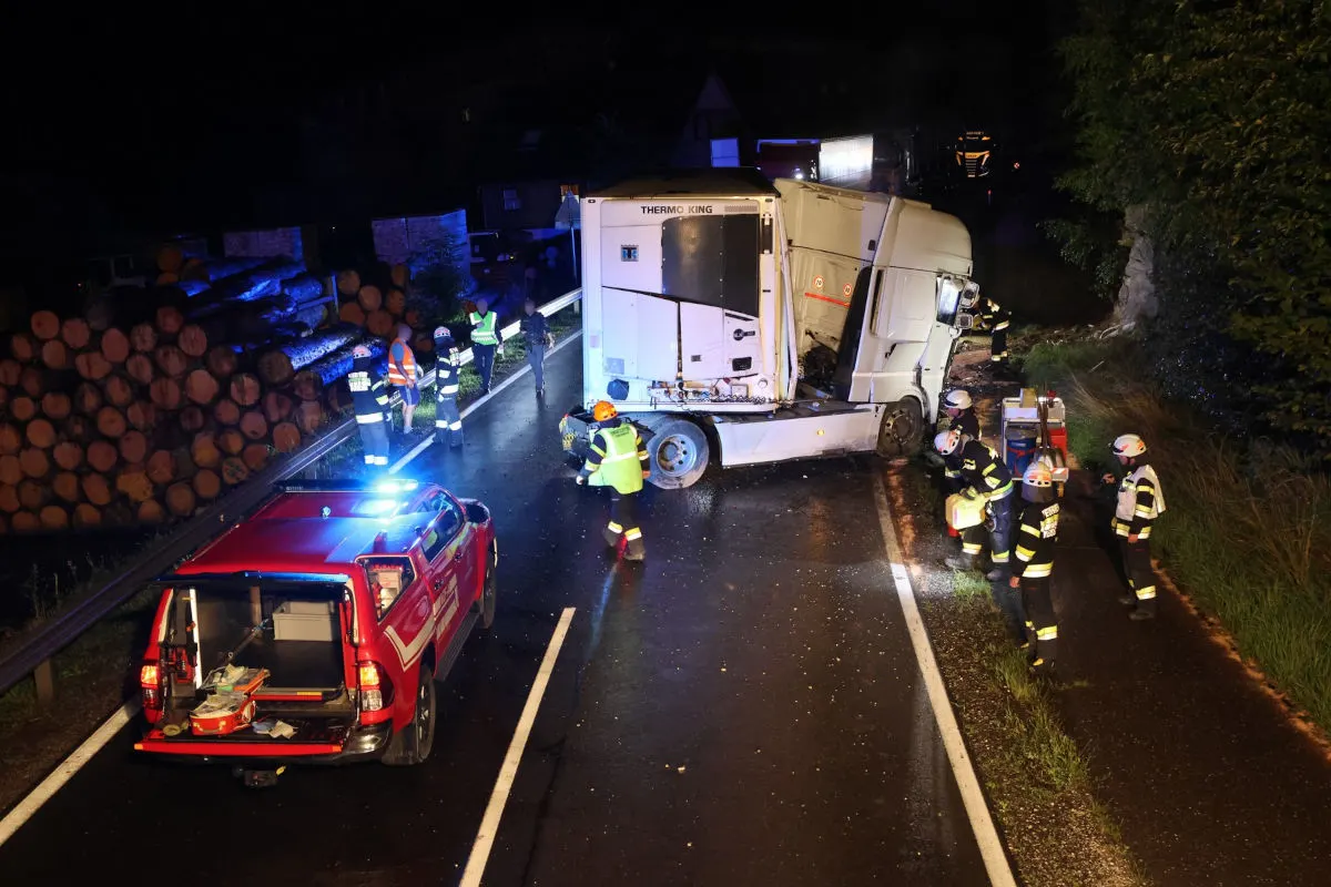 Einsatzkräfte stehen neben einem verunglückten Lkw auf einer abendlichen Landstraße mit beleuchteten Einsatzfahrzeugen.