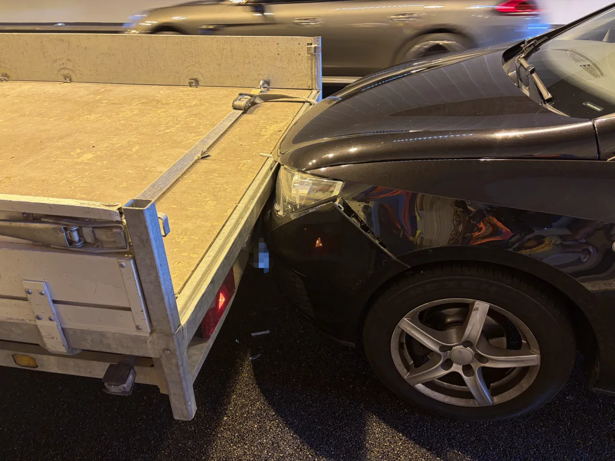 Ein schwarzes Auto ist im Tunnel auf einen geparkten Anhänger aufgefahren. Im Hintergrund fährt ein weiteres Auto vorbei.