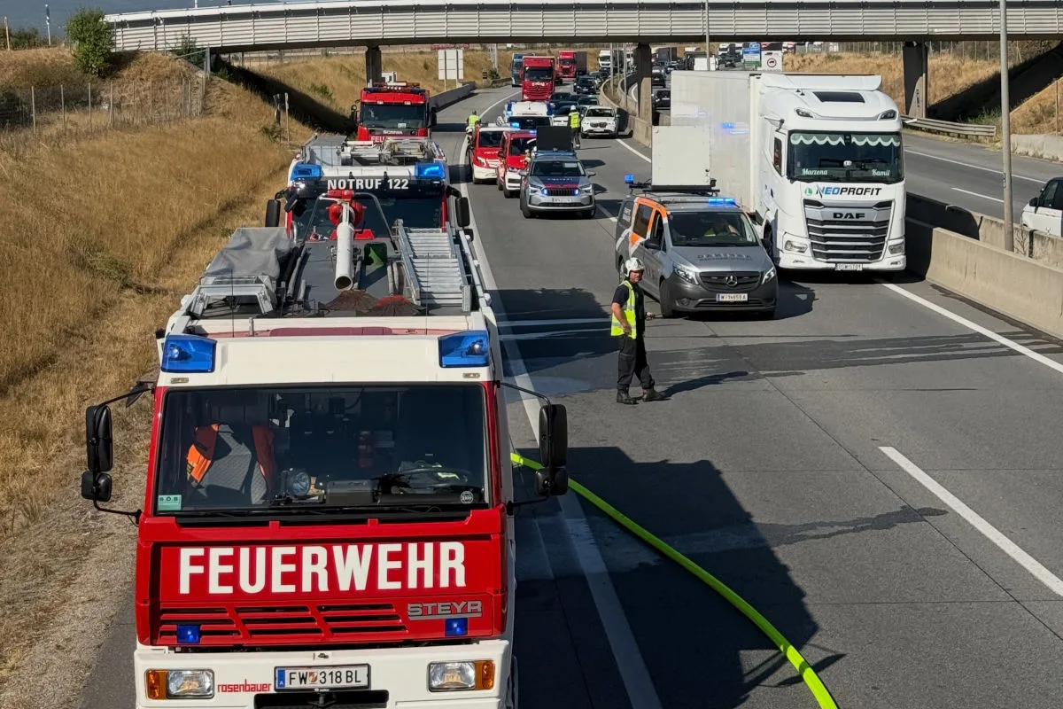 Mehrere Einsatzfahrzeuge der Feuerwehr und Polizei sind auf einer Autobahn im Einsatz, umgeben von Stau.