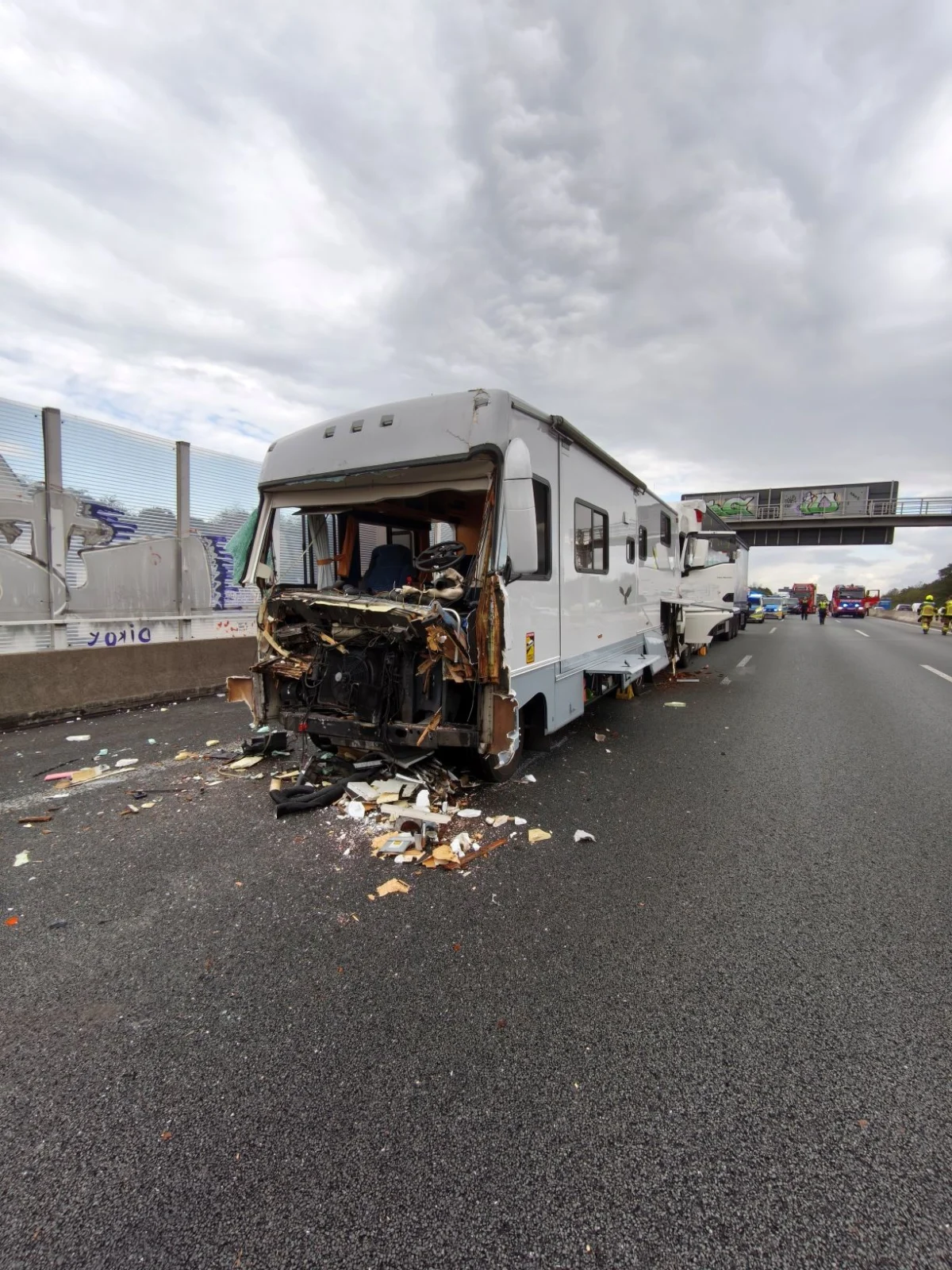 Ein Wohnmobil mit stark zerstörter Front steht auf der Autobahn. Trümmer sind auf der Fahrbahn verstreut.