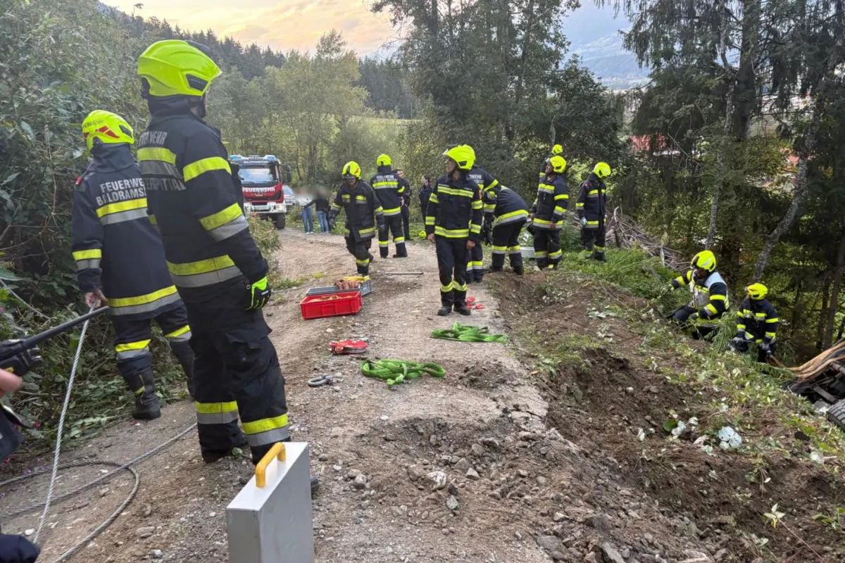 Mehrere Feuerwehrleute in Schutzkleidung sind um einen Hang herum verteilt und arbeiten an einem Einsatzort im Wald.