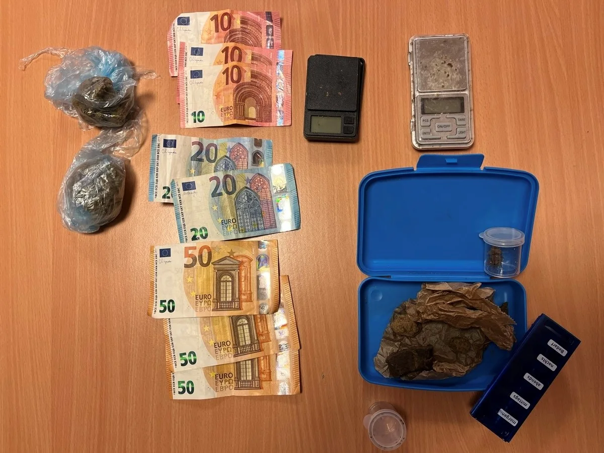Auf einem Tisch liegen Plastiktüten mit Drogen, mehrere Euro-Banknoten und zwei Waagen. Daneben eine geöffnete blaue Box mit weiteren Gegenständen.
