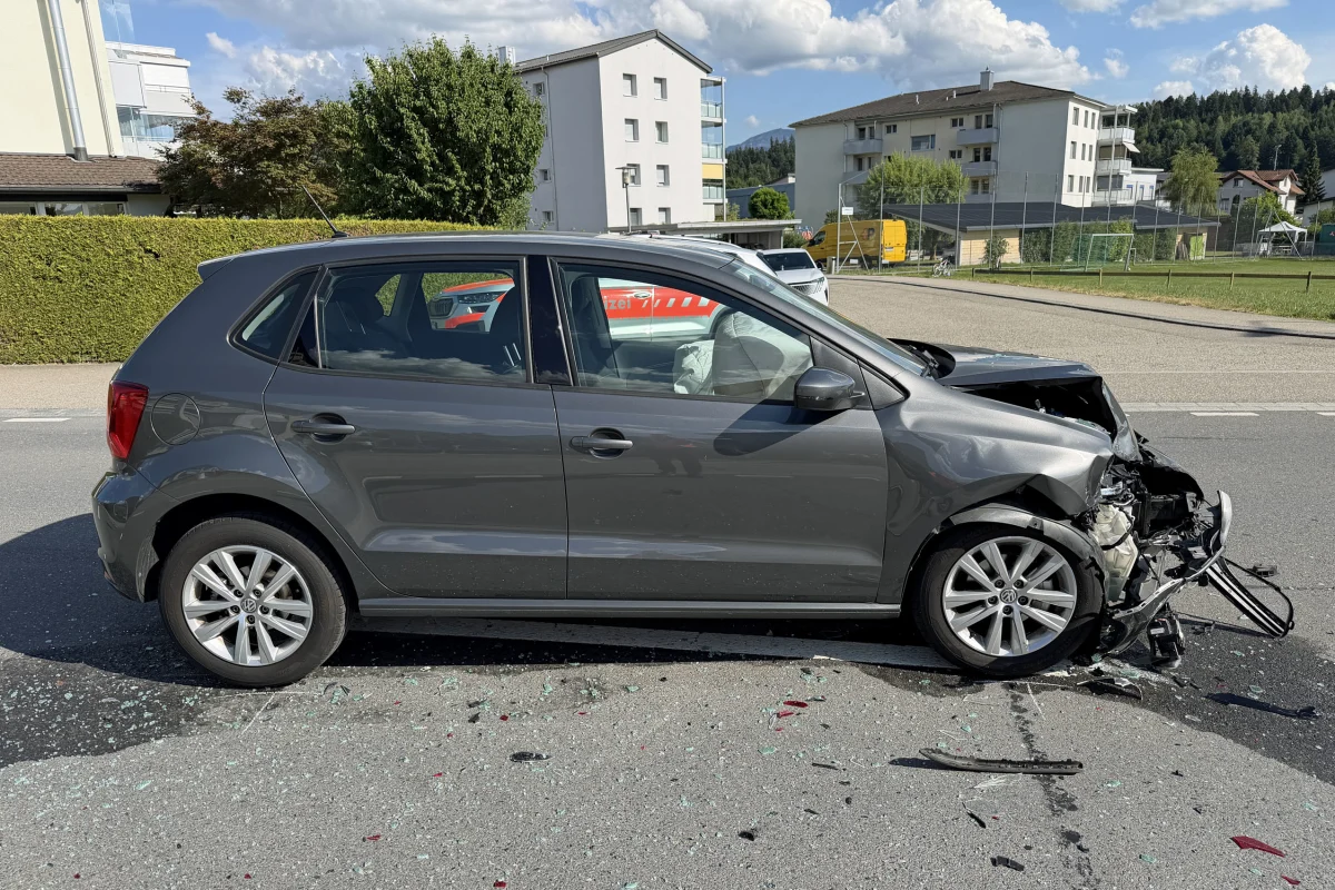 Ein graues Auto zeigt erhebliche Frontalbeschädigungen nach einem Unfall. Im Hintergrund sind Wohngebäude sichtbar.