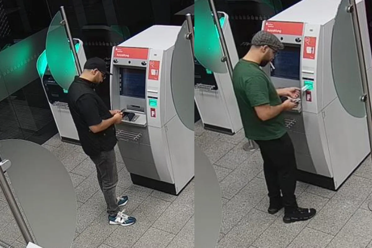 Zwei Männer stehen hintereinander an einem Geldautomaten und bedienen ihn. Der Automat befindet sich in einer Bankfiliale.
