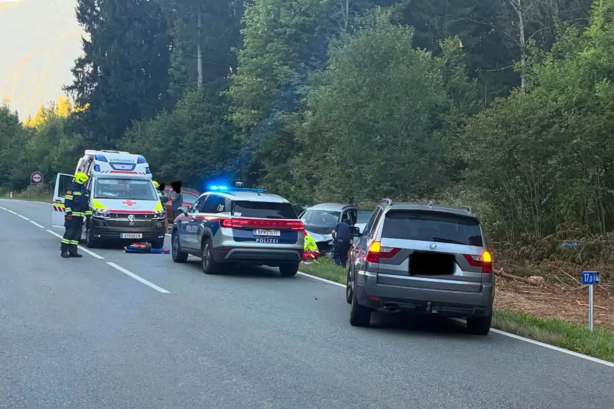 Ein Polizeifahrzeug und ein Rettungswagen stehen auf einer Landstraße. Einsatzkräfte sind sichtbar aktiv.