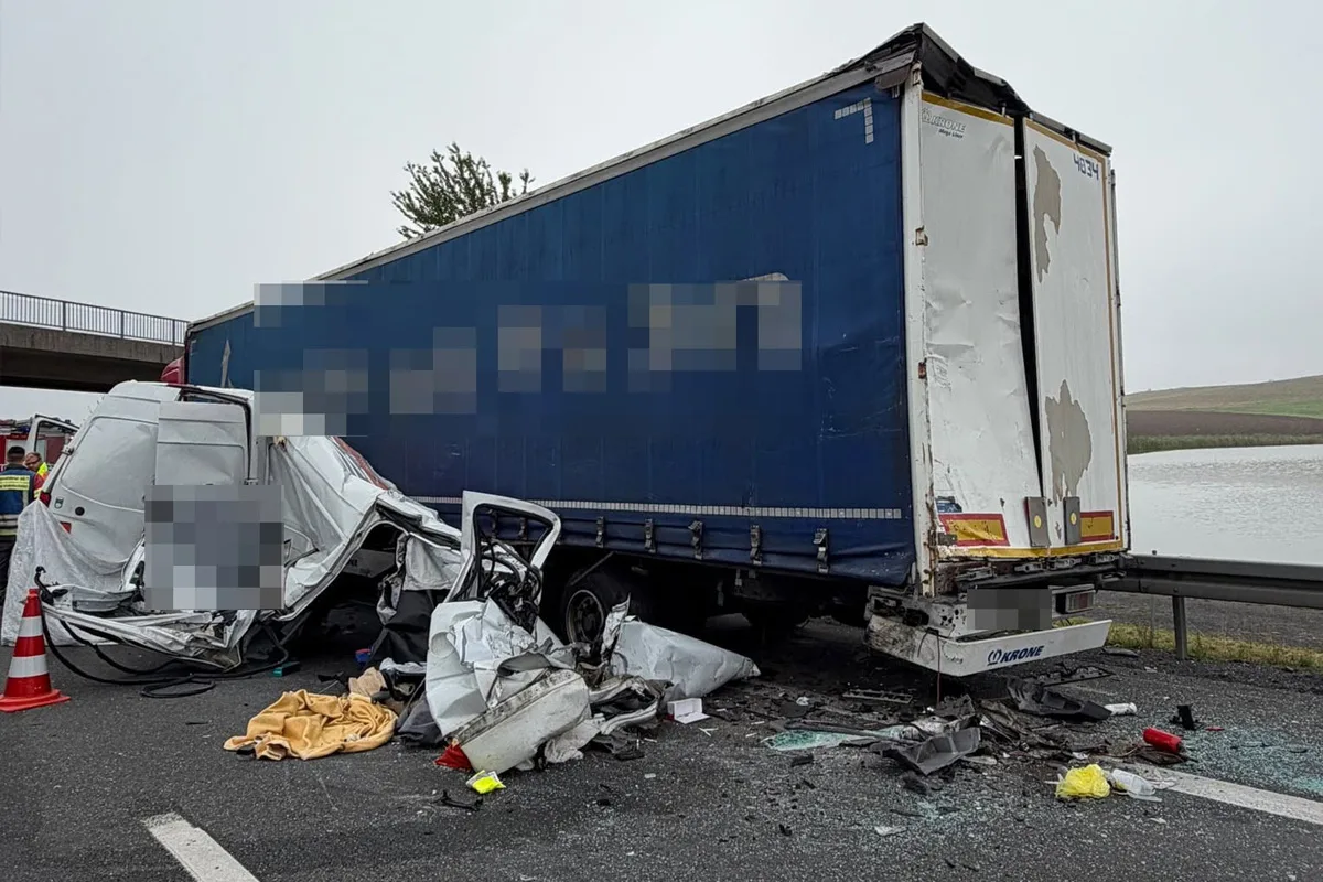 Ein Transporter ist in einen Lastwagen auf der Autobahn geprallt, beide Fahrzeuge zeigen schwere Schäden. Trümmer liegen verstreut.