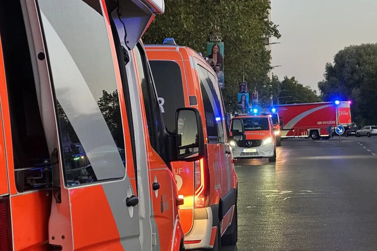 Mehrere Rettungsfahrzeuge mit eingeschaltetem Blaulicht stehen auf einer Straße. Es ist Abenddämmerung.