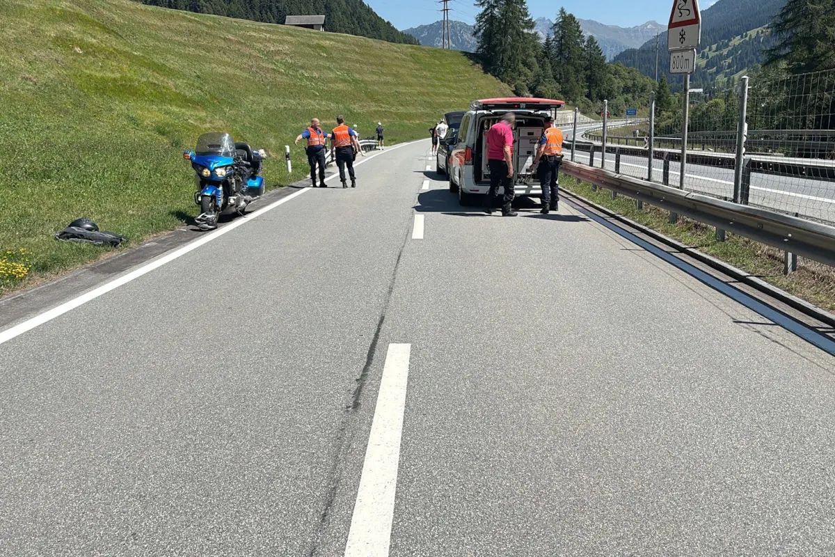 Mehrere Polizisten stehen neben einem beschädigten blauen Motorrad auf einer Straße in der Berglandschaft; ein Polizeifahrzeug ist im Einsatz.