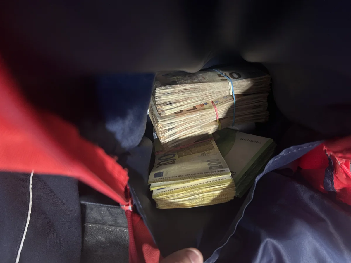 In einem Rucksack sind mehrere Bündel Bargeld sichtbar, die mit Gummibändern zusammengehalten werden.