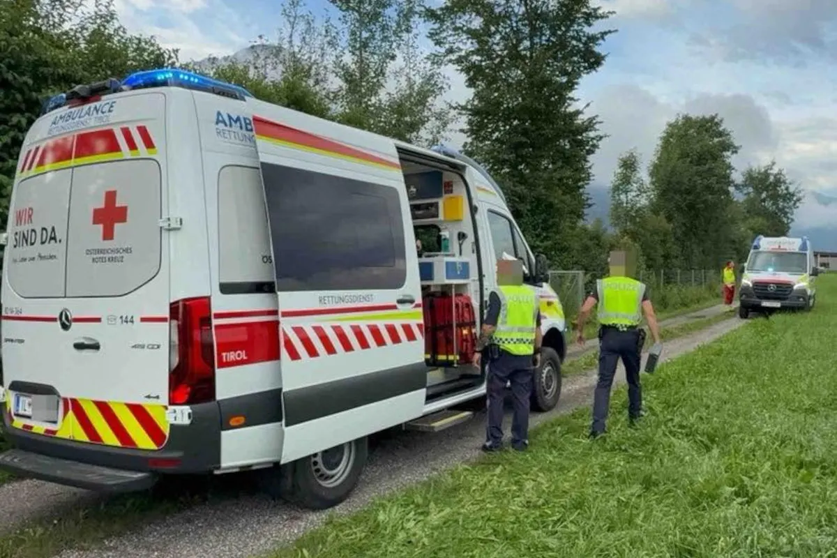 Zwei Ambulanzfahrzeuge des Roten Kreuzes mit Polizisten stehen auf einem Feldweg. Die Szene spielt sich in Tirol ab.
