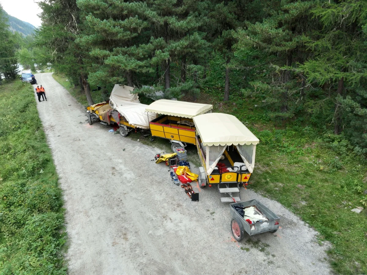 Ein beschädigter Pferdewagen steht am Rand eines Waldwegs. Zwei Personen in Einsatzkleidung stehen in der Nähe.